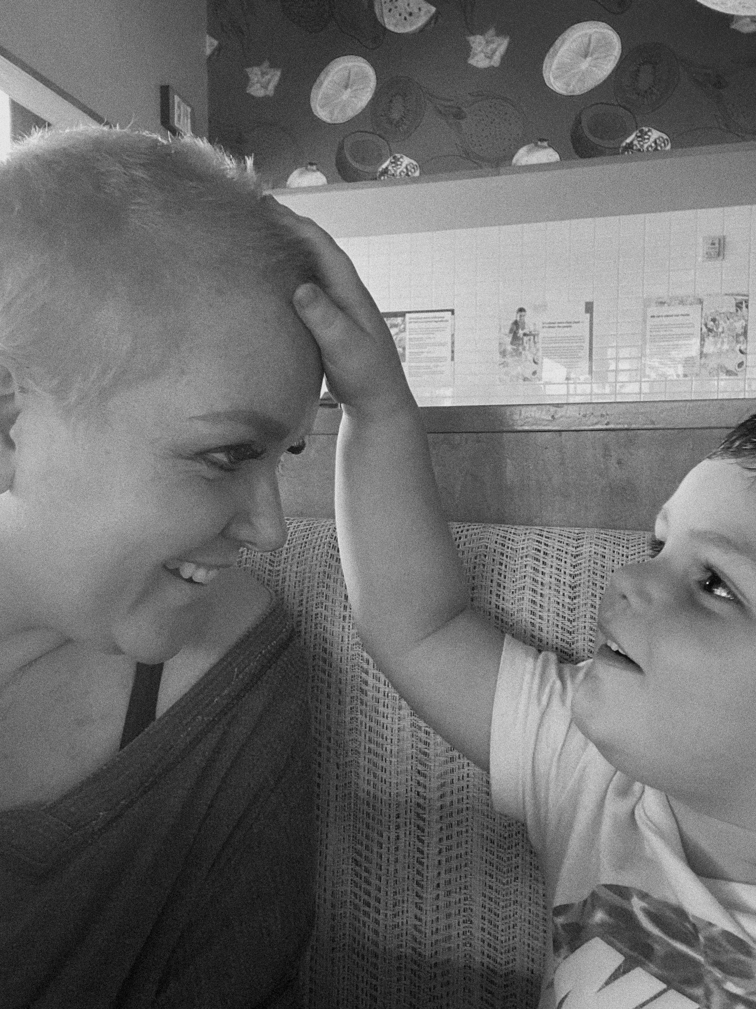 Savannah and her son smiling with her son touching her shaved head